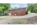 Brick home with a large driveway and detached garage, nestled in lush greenery at 256 Indian Trl, Marietta, GA 30068