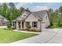 Well-maintained home showcasing manicured landscaping, an extended driveway, and attached garage at 7070 Concord Mountain Trl, Cumming, GA 30028