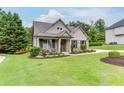 Beautifully landscaped front yard with lush green lawn surrounding a charming brick and siding home at 7070 Concord Mountain Trl, Cumming, GA 30028