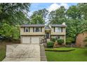 Charming two-story home featuring a stone facade, double garage, landscaped yard, and inviting entryway at 735 Waterbrook Ter, Roswell, GA 30076