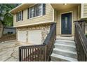 Inviting home entrance with a decorative front door, stone accents, and an attached two-car garage at 735 Waterbrook Ter, Roswell, GA 30076