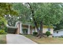 Attractive yellow home with brick accents, covered parking, and lush landscaping enhance the property's appeal at 2510 Brentwood Ct, Decatur, GA 30032