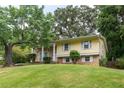 Inviting yellow home with brick accents, well-manicured lawn, and mature trees create a welcoming exterior at 2510 Brentwood Ct, Decatur, GA 30032