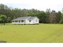 Exterior view of a home with a well maintained lawn and long front porch at 124 Wynn Rd, Mcdonough, GA 30252