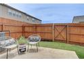 Cozy backyard featuring a wood fence, a small patio with chairs, and a well-maintained lawn at 7682 Baron Rd, Fairburn, GA 30213