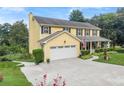 Yellow home featuring an attached garage, well maintained lawn and driveway at 1083 Wash Lee Sw Dr, Lilburn, GA 30047