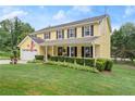 Inviting yellow home with black shutters, a front porch, and a well-maintained lawn at 1083 Wash Lee Sw Dr, Lilburn, GA 30047