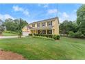 Yellow home with a manicured lawn and tidy landscaping at 1083 Wash Lee Sw Dr, Lilburn, GA 30047