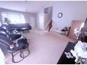 Bright living room boasts neutral paint, plush carpet, large windows, and a staircase at 2331 Georgia Lane, Snellville, GA 30078