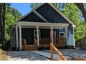 Inviting exterior featuring a covered front porch, gravel, manicured landscape and a bright red door at 1321 Bridges Sw Ave, Atlanta, GA 30310