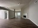 Spacious living room featuring a fireplace, ceiling fan, and dark wood flooring, creating a cozy and inviting atmosphere at 3718 Jackson Bluff Dr, Lawrenceville, GA 30044