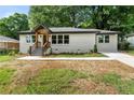 Inviting single-story home features a manicured lawn and a charming brick facade with a modern entryway at 2244 Alpha Dr, Decatur, GA 30032