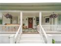 Inviting front porch with steps, seating, hanging plants, and a beautifully decorated front door with a wreath at 4527 Dallas St, Acworth, GA 30101