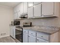 Modern kitchen features stainless steel appliances, granite countertops, and painted cabinets at 50 Carriage Trce, Stockbridge, GA 30281