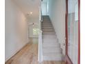 Bright entryway featuring light wood flooring, a staircase with gray carpeting, and an open view into a living space at 3006 Sea Aster Way, Buford, GA 30519
