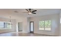 Open-concept living room with sleek ceiling fan, hardwood floors, and natural light from large windows at 3006 Sea Aster Way, Buford, GA 30519