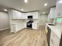 Modern kitchen featuring white cabinets, stainless steel appliances, and sleek countertops at 336 Shady Lane Cir, Canton, GA 30115