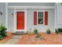 Inviting townhome entrance with a red front door and well-manicured landscaping at 3999 Bayside Cir, Doraville, GA 30340