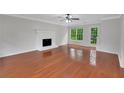 Spacious living room featuring hardwood floors, white brick fireplace, and lots of natural light at 4009 Riverstone Dr, Suwanee, GA 30024