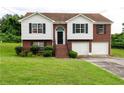 Charming two-story home with a well-manicured lawn, brick facade, and attached two-car garage at 4527 Berline Dr, Lithonia, GA 30038