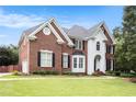 Elegant two-story home with a well-maintained lawn, brick facade, and inviting front entrance at 650 Garden Wilde Place, Roswell, GA 30075