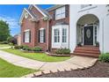 Charming home entrance with manicured landscaping and a curved walkway leading to the front door at 650 Garden Wilde Place, Roswell, GA 30075