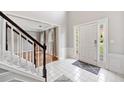Bright foyer with tile flooring, staircase, and views to the living room and front door at 4780 Agate Dr, Johns Creek, GA 30022
