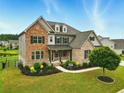 Inviting home featuring a combination of brick and stone, complemented by vibrant landscaping and a green lawn at 847 Rolling Hill, Kennesaw, GA 30152