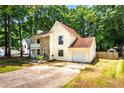 Lovely two-story home with stone detail, a covered porch, attached garage, and long driveway at 2568 Redfield Dr, Norcross, GA 30071