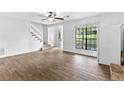 Bright living room with wood floors, a ceiling fan, large windows, and a staircase at 2568 Redfield Dr, Norcross, GA 30071