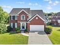 Charming two-story red brick home with a two-car garage and well-manicured lawn at 3226 Masters Pass Ln, Snellville, GA 30039