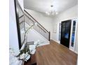 Welcoming foyer with wood floors, staircase, modern light fixture, and front door at 3226 Masters Pass Ln, Snellville, GA 30039