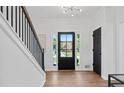 Bright foyer with hardwood floors, staircase, and stylish black front door at 3226 Masters Pass Ln, Snellville, GA 30039