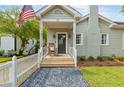 Inviting covered front porch with rocking chair and American flag creating a welcoming entrance to the home at 67 Trammell Sw St, Marietta, GA 30064