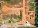 Overhead view of new construction site featuring graded lots, access roads, and heavy construction equipment at 15 Dartmoor Cir, Dallas, GA 30157