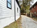 Side view of a home showing the new siding, trim, and a driveway leading to a fenced backyard at 701 Cameron M Alexander Nw Blvd, Atlanta, GA 30318