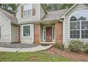 Inviting front entryway with red brick accents, a modern front door, and a well-maintained walkway at 3404 Bodiford Path Path, Powder Springs, GA 30127