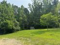 A grassy backyard shows a storage shed and some sparse trees at 361 West Ave, Dallas, GA 30157