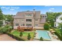Stunning backyard features a refreshing pool with lounge chairs, a spacious deck, and mature trees at 4530 Westgate Dr, Cumming, GA 30040