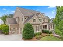 Elegant home showcasing a two-car garage, beautifully landscaped yard, and classic architectural details at 4530 Westgate Dr, Cumming, GA 30040