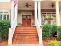 Close-up view of the front porch, featuring a wood door, white railings, and ceiling fans at 4530 Westgate Dr, Cumming, GA 30040