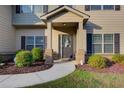Close-up of front door with wreath, manicured shrubs, and a walkway at 3746 Okefenokee Rdg, Loganville, GA 30052