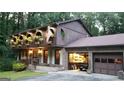 Two-story home with balconies showcasing flower boxes and an attached garage with open door at 4567 Town Crier Sw Rd, Lilburn, GA 30047