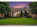 Charming brick home featuring lush green lawns, mature trees, and architectural details at sunset at 1241 Edgebrook Ln, Snellville, GA 30078