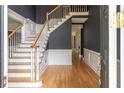 Grand foyer showcasing hardwood floors, a staircase, and dark gray walls with bright white trim at 3801 Stonebriar Ln, Duluth, GA 30097
