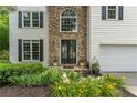 Elegant entryway featuring a stone facade, double doors, and manicured landscaping at 3801 Stonebriar Ln, Duluth, GA 30097