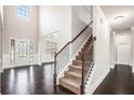 Entryway featuring hardwood floors, a carpeted staircase, wainscoting, and a decorative front door at 726 Independence Ln, Acworth, GA 30102
