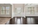 Elegant foyer boasting dark hardwood floors, windows, and decorative front door with ornate glass design at 726 Independence Ln, Acworth, GA 30102