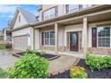 Covered porch with brick accents and manicured landscaping leads to the front door and garage at 726 Independence Ln, Acworth, GA 30102