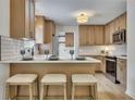 Modern kitchen featuring light wood cabinets, stainless appliances, and breakfast bar at 2265 Colony Dr, Canton, GA 30114